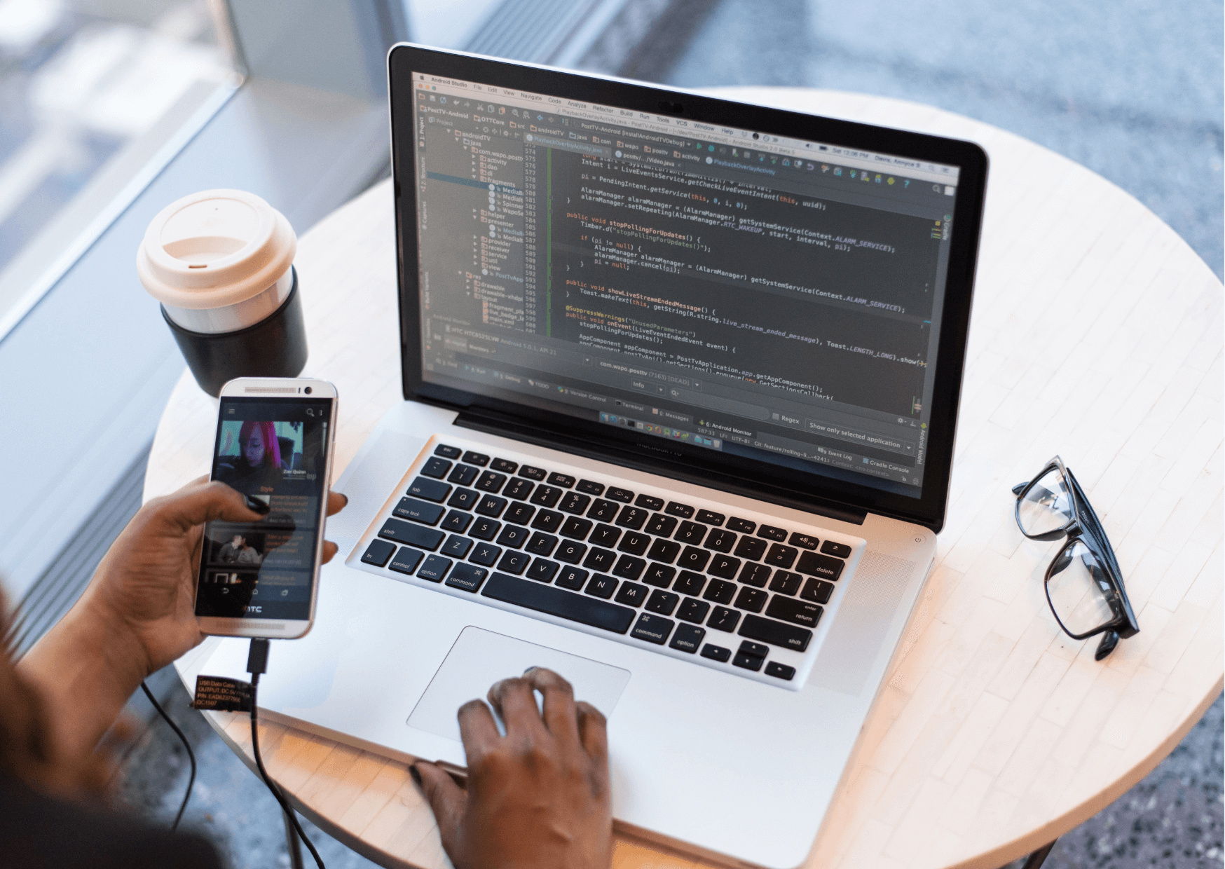 A laptop, phone and coffee on a desk